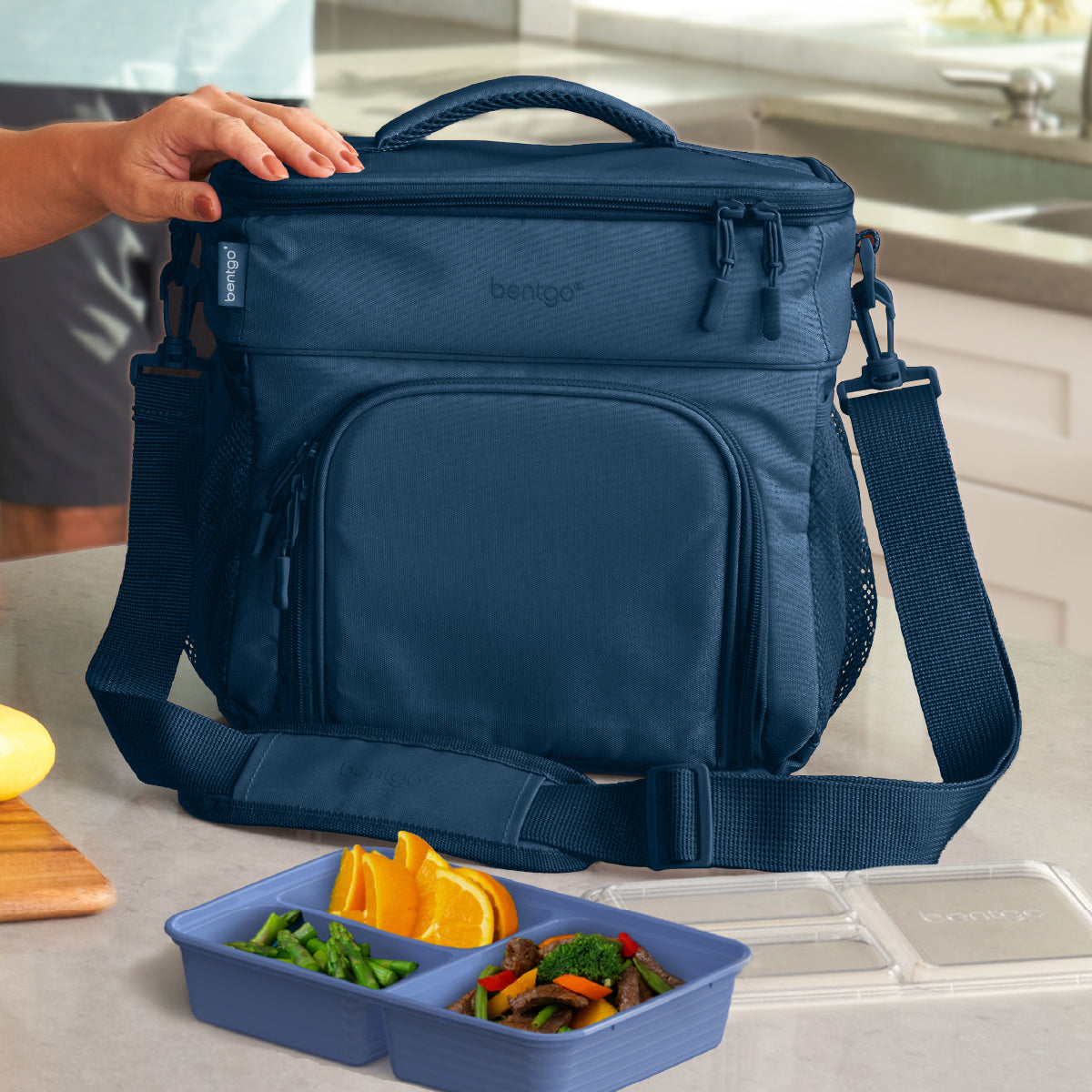 Blue lunch bag with compartments on a kitchen counter