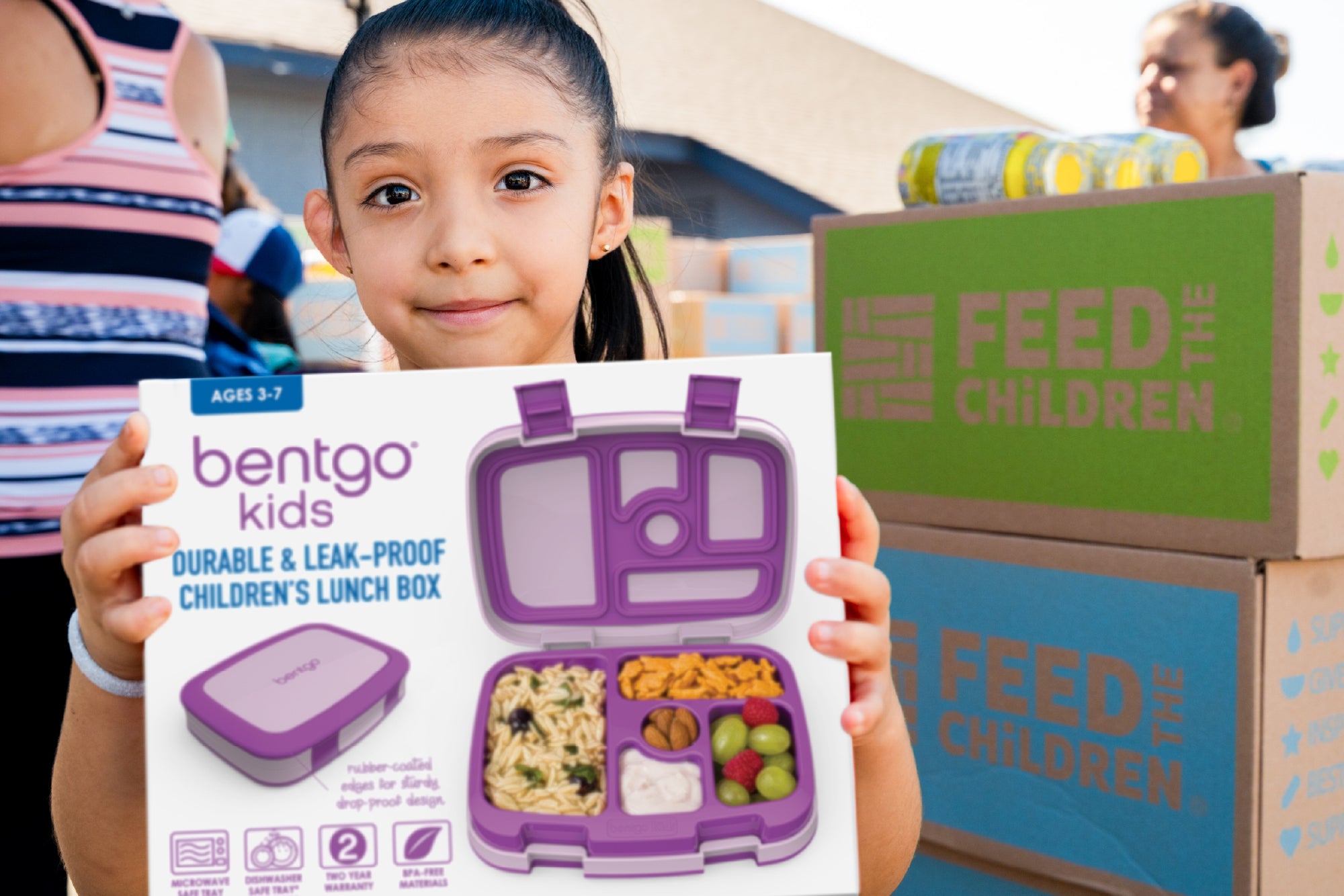 Child holding a Bentgo lunch box packaging in an outdoor setting