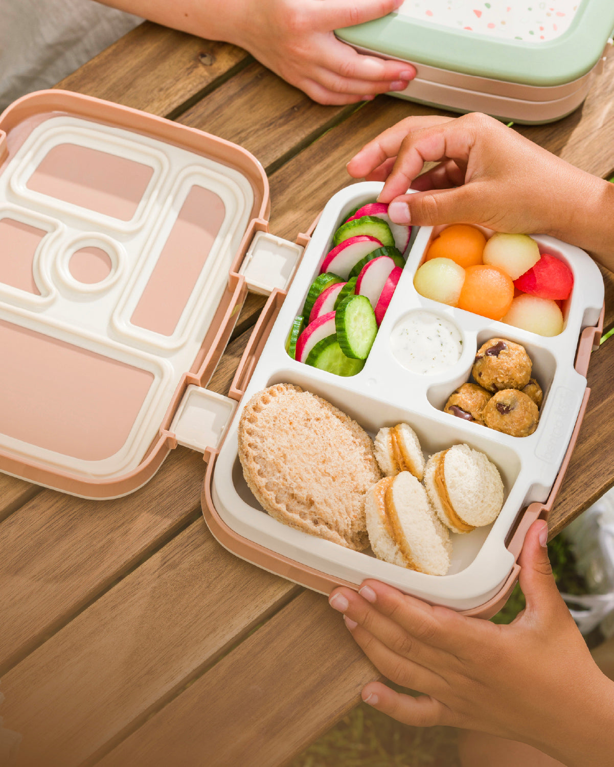 Bento box with various food items on a wooden table