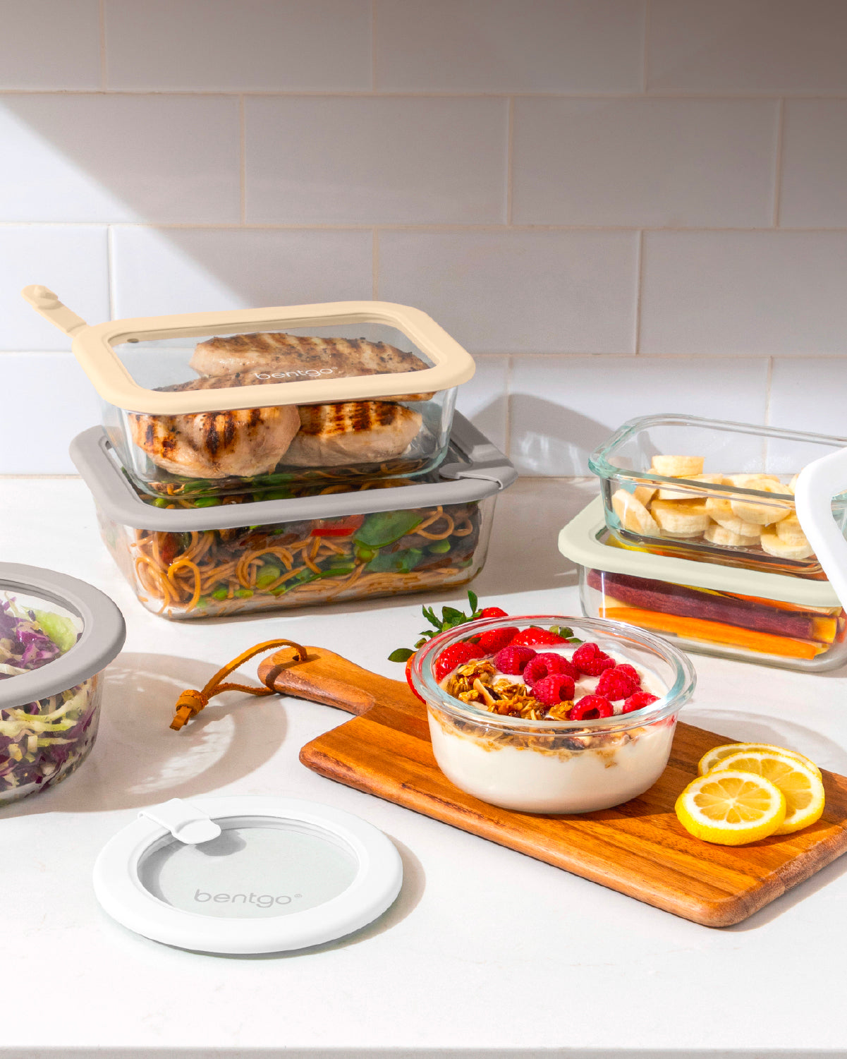 Glass food storage containers with lids on a kitchen counter.