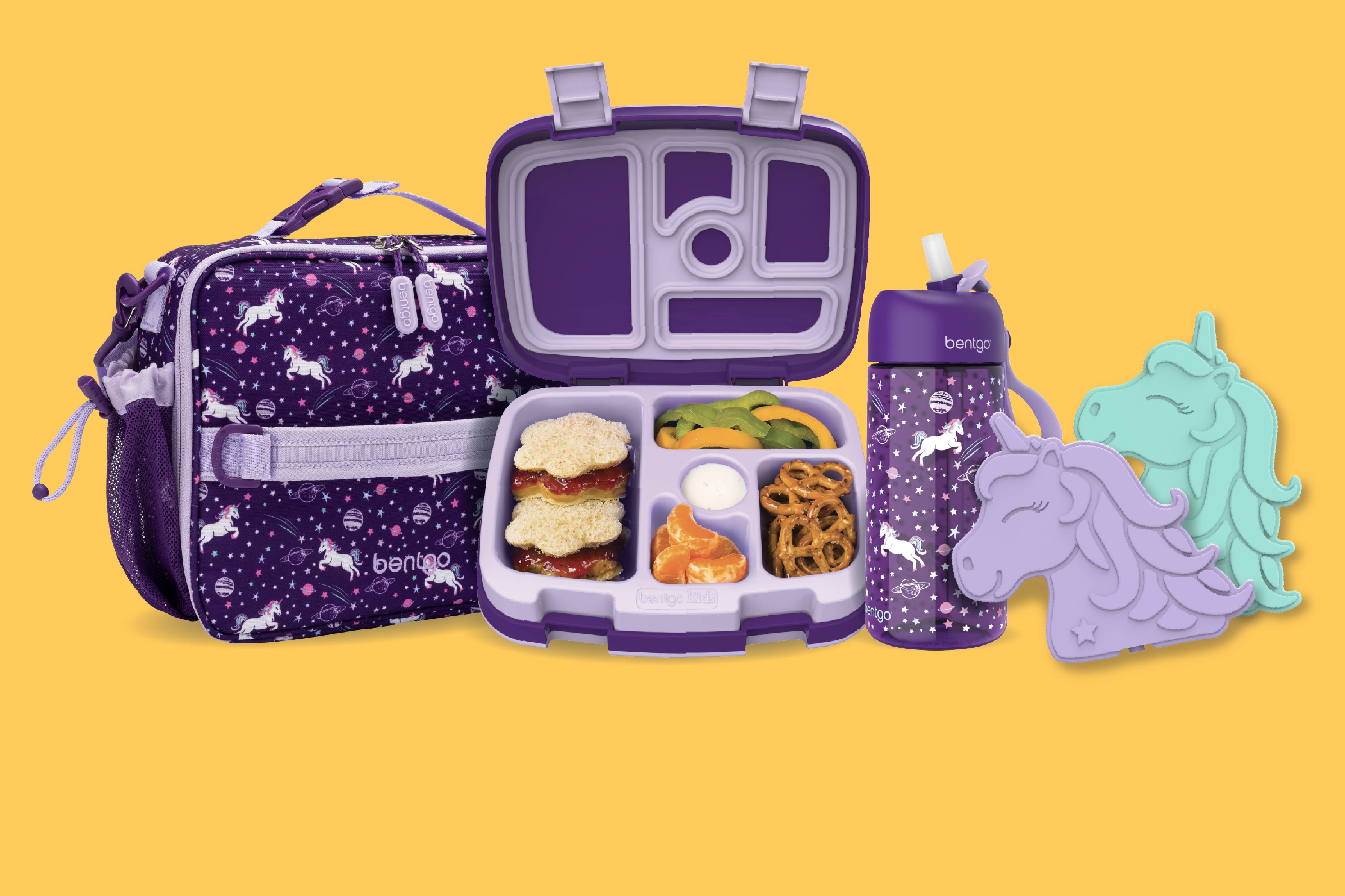 Purple lunch bag, bento box, water bottle, and silicone snack case on a yellow background